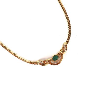 une photo d'un collier en or orné d'une pierre verte