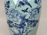 un vase bleu et blanc orné d'un oiseau et de fleurs