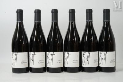 six bouteilles de vin sont alignées sur une table