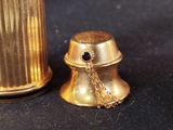 a gold bell with a chain around it on a black surface