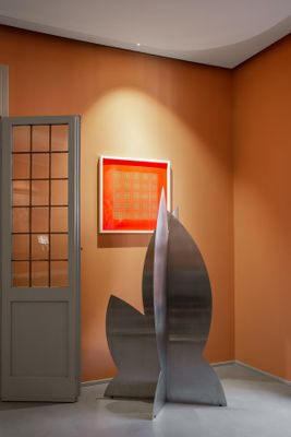 une sculpture au milieu d'une pièce aux murs orange