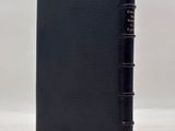 a black leather bound book with a gold clasp on the front