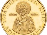 a close up of a gold coin with an image of a saint