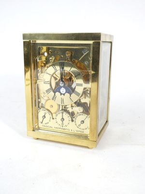 a gold clock that is sitting on a white surface