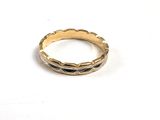 gros plan d'une bague en or sur une surface blanche