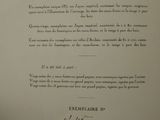 an old book with a black and white image of a man ' s hand holding up a piece of paper with writing on it