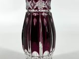 un vase en verre violet orné d'un motif floral