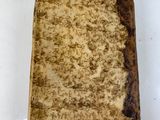 an old book sitting on top of a white table covered in dirt