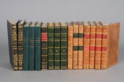 several old books are lined up in a row on a gray surface