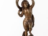 an antique bronze figurine of a boy holding a bird on a pedestal