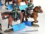 many figurines of people riding horses on display