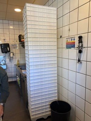un homme qui se tient dans une cuisine à côté d'une poubelle