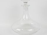 clear glass decanter on a white surface with a white background