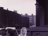 black and white photograph of two women in a convertible car on a city street