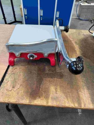 a red and silver stove sitting on a wooden table