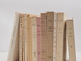 several books are stacked on top of each other on a white surface