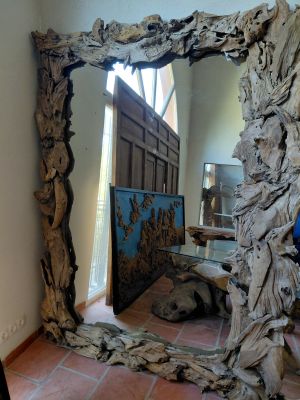 a large mirror made out of drift wood in a room