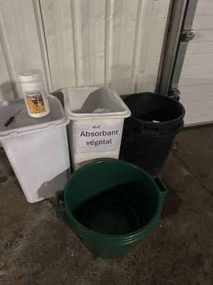 trois seaux et un flacon de médicaments posés par terre