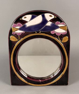 une photo d'un miroir orné d'un motif représentant un oiseau