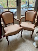 Paire de fauteuils cabriolet en bois naturel teinté reposant…