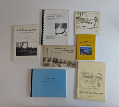 plusieurs livres posés sur un mur blanc, surmonté d'une horloge