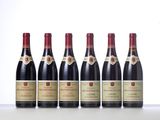 six bottles of red wine lined up in a row