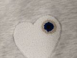 a white heart with a blue eye on it