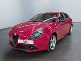 La voiture Alfa rouge est garée dans une grande pièce.