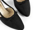 a pair of black shoes on a white surface with a white background