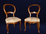 two wooden chairs with upholstered seats against a dark blue background