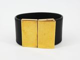 un gros plan sur un bracelet noir et doré muni d'une boucle carrée