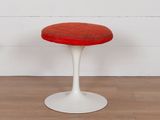 une photo d'un tabouret en forme de tulipe rouge et blanche posé sur un parquet