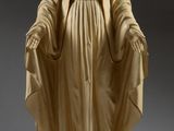 a statue of a woman in a white robe holding a cross