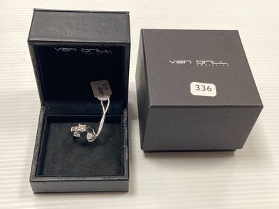 une boîte ouverte posée sur une table, contenant une bague à l'intérieur