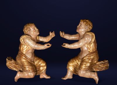 deux statues représentant un homme et une femme sont assises sur une surface bleue