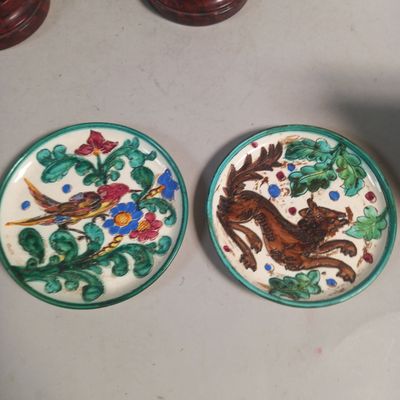 deux assiettes ornées d'oiseaux et de fleurs, posées sur une table