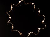un collier en or orné de perles sur fond noir