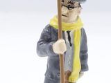 figurine of a man holding a sign that says le fond de l ' air est foas