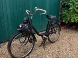 a black bicycle parked in front of a green wall