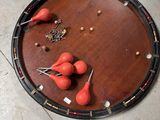 un plateau en bois posé par terre, sur lequel se trouvent des boules rouges