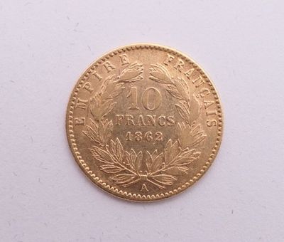 gros plan d'une pièce d'or sur une surface blanche