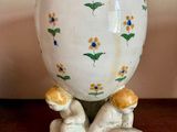 un vase blanc orné de fleurs jaunes et bleues