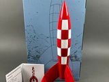 a red and white rocket sitting next to a blue and white box