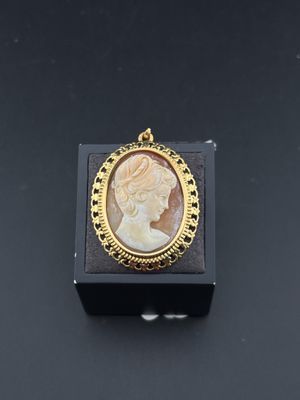 un pendentif camée plaqué or représentant le profil d'une femme au centre