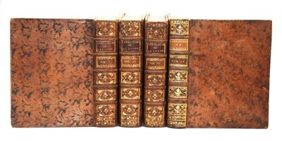 trois vieux livres posés l'un sur l'autre sur une surface blanche