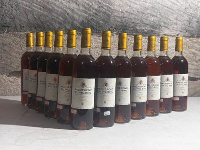 several bottles of wine are lined up in a row in front of a stone wall