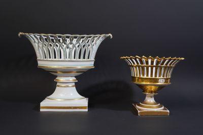 pair of white and gold vases on pedestals against a black background