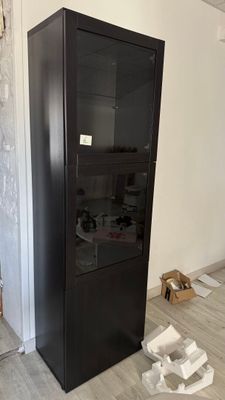 a black cabinet with a glass door in a room
