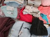 a pile of baby clothes and other items on a table