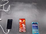 trois téléphones portables branchés sur un chargeur